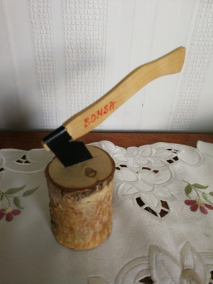 Kiva sisustuskoriste kirves pölkyssä