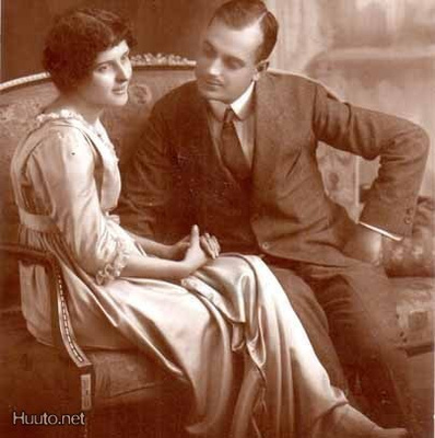 RAKKAUS / Mies jututtaa sohvalla istuvaa tyttöä. 1900-l.