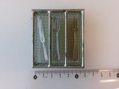 Miniatyyri vanhat ruokailuvälineet metallisessa korissa