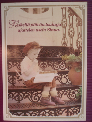 Poika istuu rappusilla lukemassa