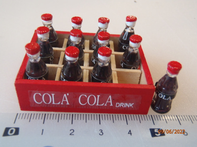 Nukkekoti cola pullot puulaatikossa