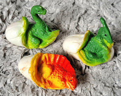 Kolme kuoriutuvaa dinosauruksen poikasta figuureina