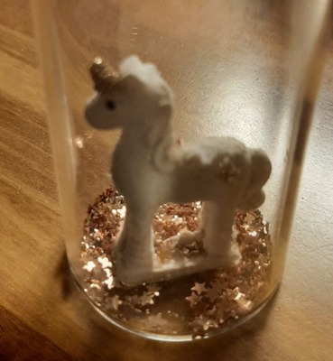 Yksisarvinen lasipullossa kimalteita
