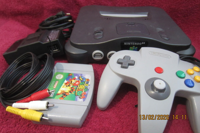 Nintendo 64 konsoli originaalit piuhat, ohjain ja Mario 64