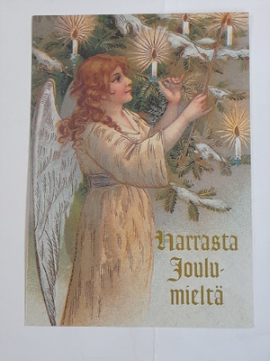 Enkeli koristelee joulukuusta
