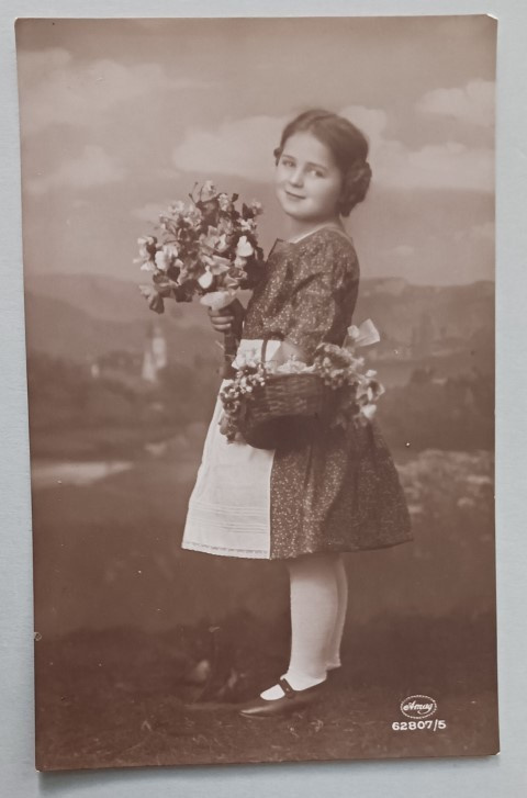 Pikkuleidi tuo onnittelukukkia käsin ja korissa, p. 1925