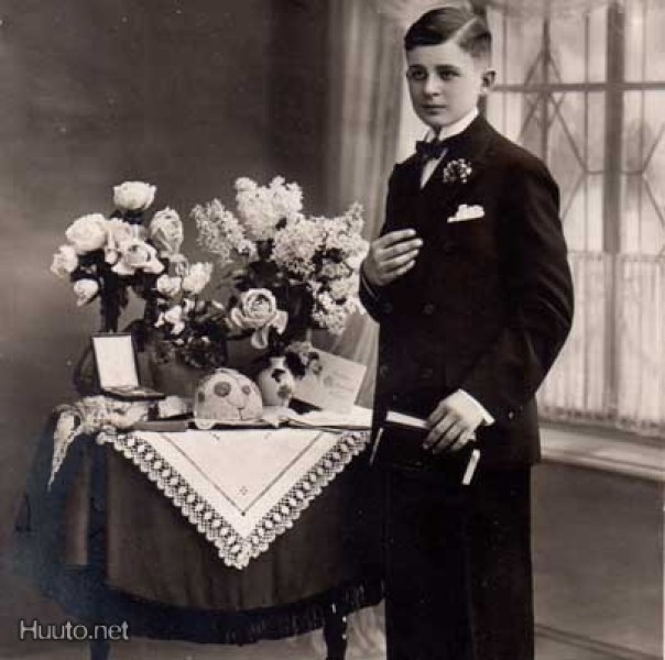 KONFIRMAATIO / Poika tummassa puvussa ja lahjapöytä. 1910-l.