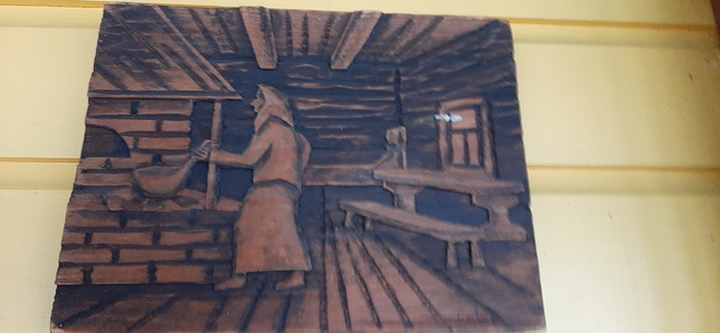 Puinen seinätaulu, vanha pirtti ja nainen