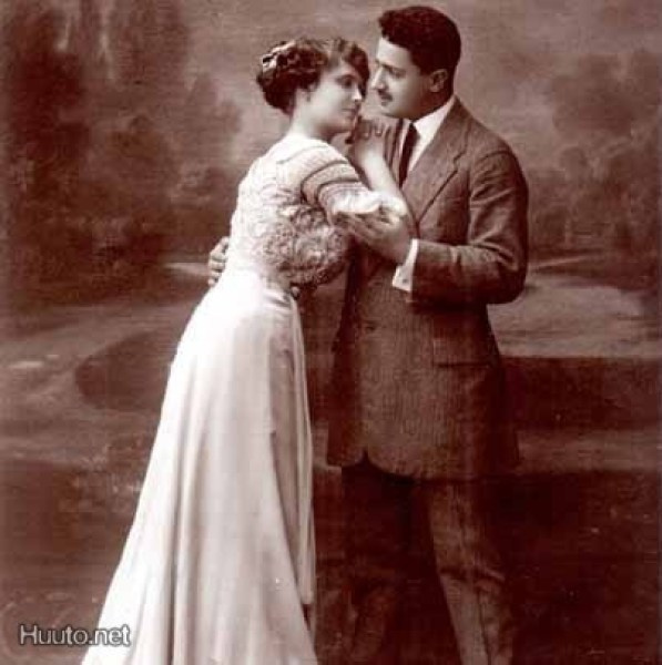 RAKKAUS / Tyttö laahusmekossa nojaa miehen olkaan. 1900-l.