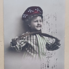 Iloinen lapsi pukemassa kaulaliinaa, väripk, p. 1911 - pikkukuva 1