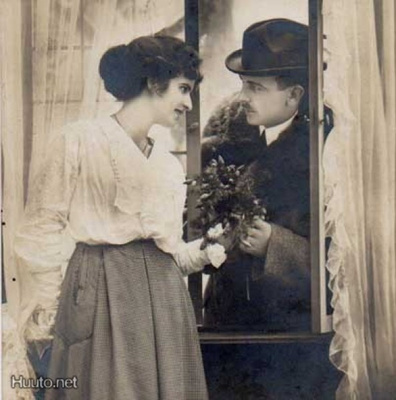RAKKAUS / Herrasmies ojentaa tytölle kukkia. 1910-l.