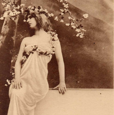 NAINEN / Valkopukuinen tyttö ja kukkiva omenapuu. 1900-l.