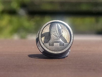 Hopeanvärinen sotaveteraanimerkki, halkaisija 11 mm. Hyväkun