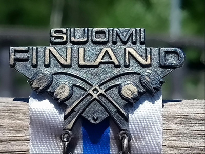 Hopeinen Suomi-Finland merkki. Suomen lipulla. Halkaisija -