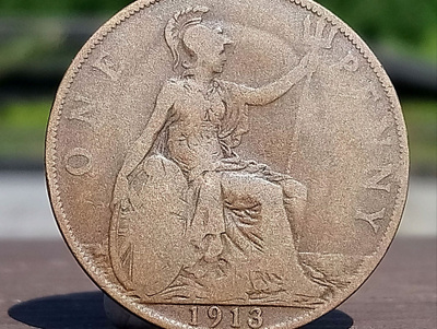 Vuoden 1913 One Penny -kolikko muovikapselissa. Halkaisija 3