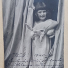 Tyttö pupu kainalossaan kurkkaa verhojen takaa, p. 1905 - pikkukuva 1