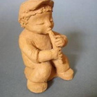 HUILUA SOITTAVA POIKA Figuuri - pikkukuva 1