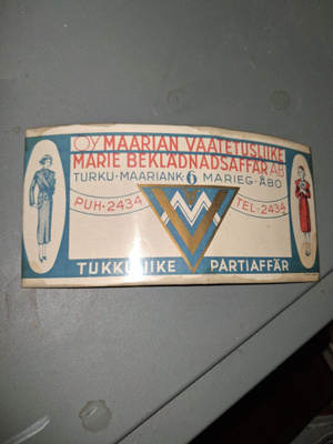 Kuvien OY Maarian vaatetusliike peltikyltti.
