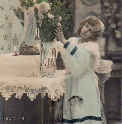 LAPSI / Tyttö asettelee kukkia salongin maljakossa. 1900-l.