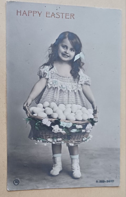 Tyttö kantaa munakoria hymyillen, vanha Pääsiäispk, p. 1906