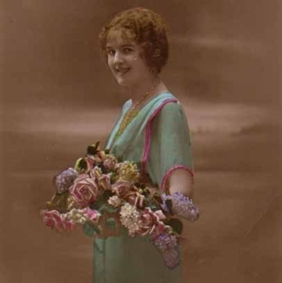 NAINEN / Hymyilevä punahiuksinen tyttö ja kukkia. 1920-l.