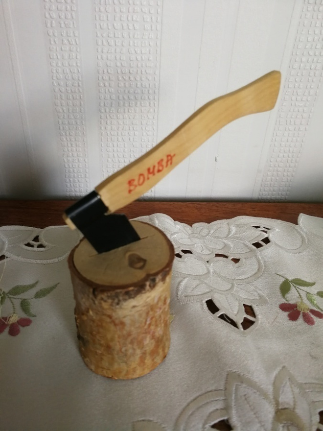Kiva sisustuskoriste kirves pölkyssä