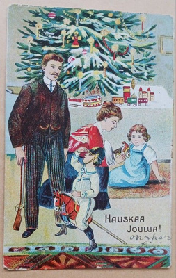 Perhe joulukuusen alla, lapset leikkivät lahjoilla, k. k-k