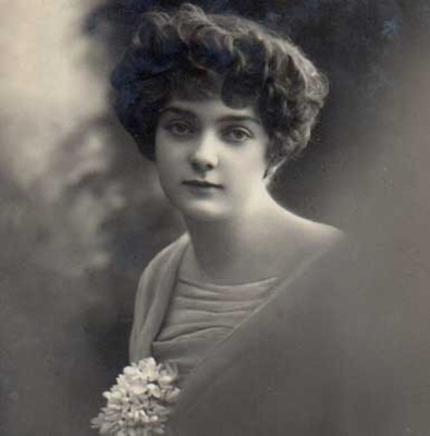 NAINEN / Suloinen tyttö valkovuokkokimppu rinnassa. 1900-l.