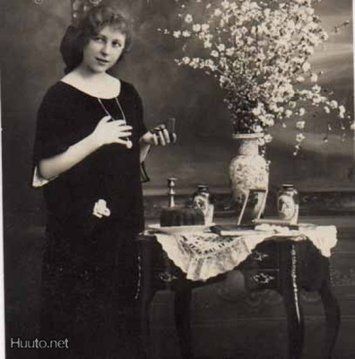 KONFIRMAATIO / Hymyilevä rippityttö ja lahjapöytä. 1920-l.