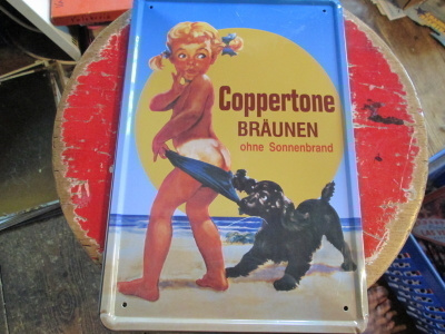 Peltikyltti mainos Coppertone. Tyttö ja cockerspanieli