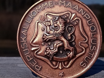 Maanpuolustus Ronssivärinen merkki. Kaiverruksella Vänrikki.