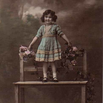 LAPSI / Puupenkillä seisova pieni tyttö, ruusuja. 1900-l.