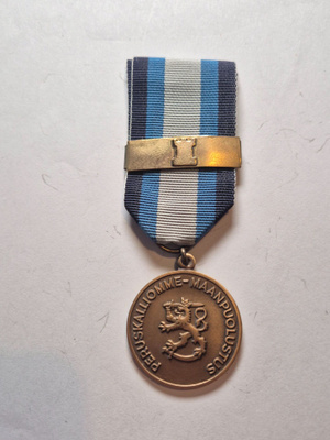 Maanpuollustusmitali soljella.