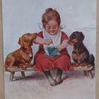 Tyttö ruokailee, mäyräkoirat katselevat, p. 1922 - pikkukuva 1