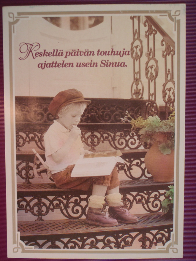 Poika istuu rappusilla lukemassa