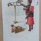 Lapset viemässä lintulaudalle jyviä ja syötävää, p .1915 - pikkukuva 1