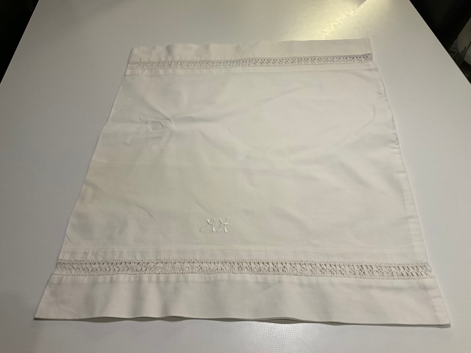 Wanha valkoinen tyynyliina, pitsit ja monogrammi