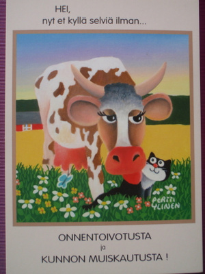 Pertti Ylinen lehmä nuolee kissaa kukkakedolla