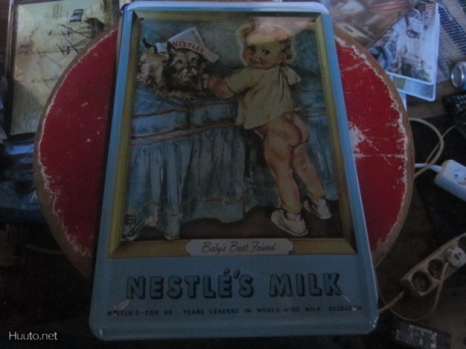 Peltikyltti Nestle maitomainos. Pikkutyttö ja terrieri