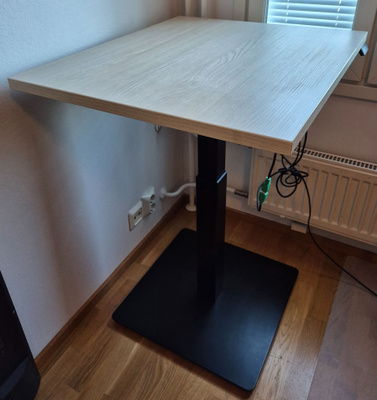 Sähköpöytä vaalea kansi mustalla jalalla