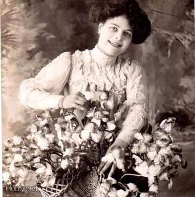 NAINEN / Hymyilevä tyttö, iso kukka-asetelma. 1900-l.