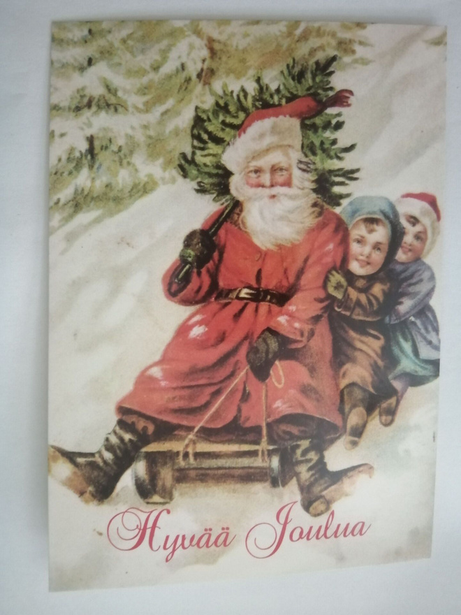 Joulupukki ja lapset  laskevat mäkeä