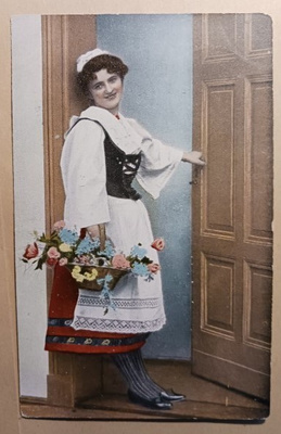 Leidi kansanpuvussa kukkien kanssa ovella, p. 1908