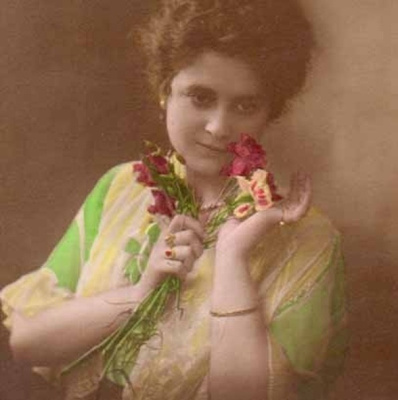 NAINEN / Runollinen tyttö ja neilikkakimppu. 1910-l.