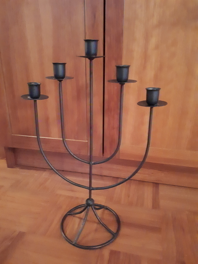 Musta metallinen kynttilänjalka pöydälle