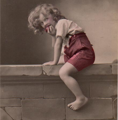 LAPSI / Poika haukkaa omenaa omenatarhan muurilla. 1910-l.