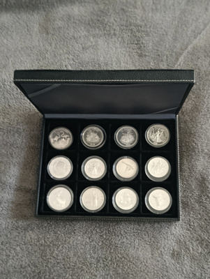 12 proof-hopeakolikkoa laatikossa