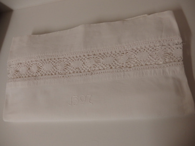 Wanha valkoinen pitsilakana, monogrammi