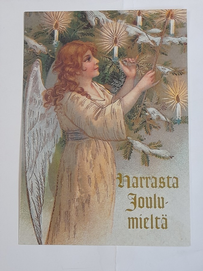 Enkeli koristelee joulukuusta