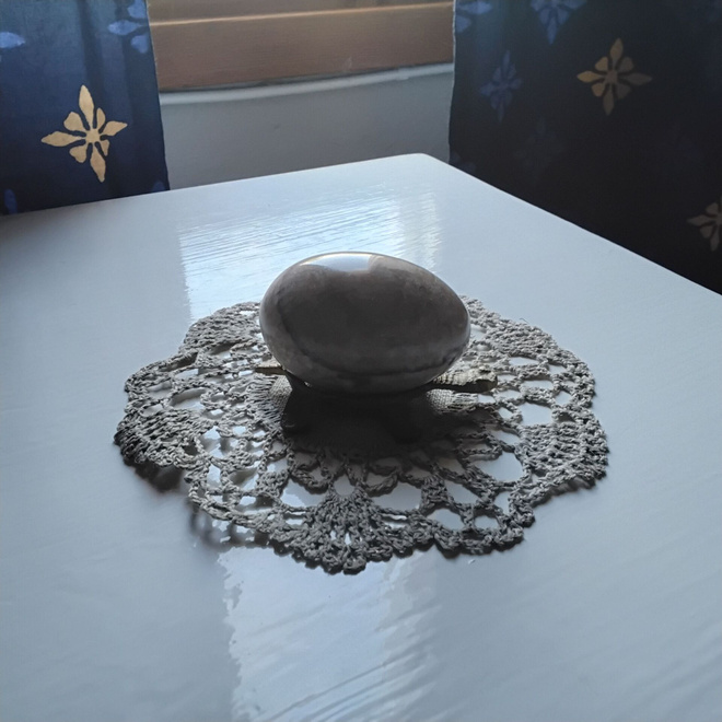 Kivimuna telineessä ja pieni liina
